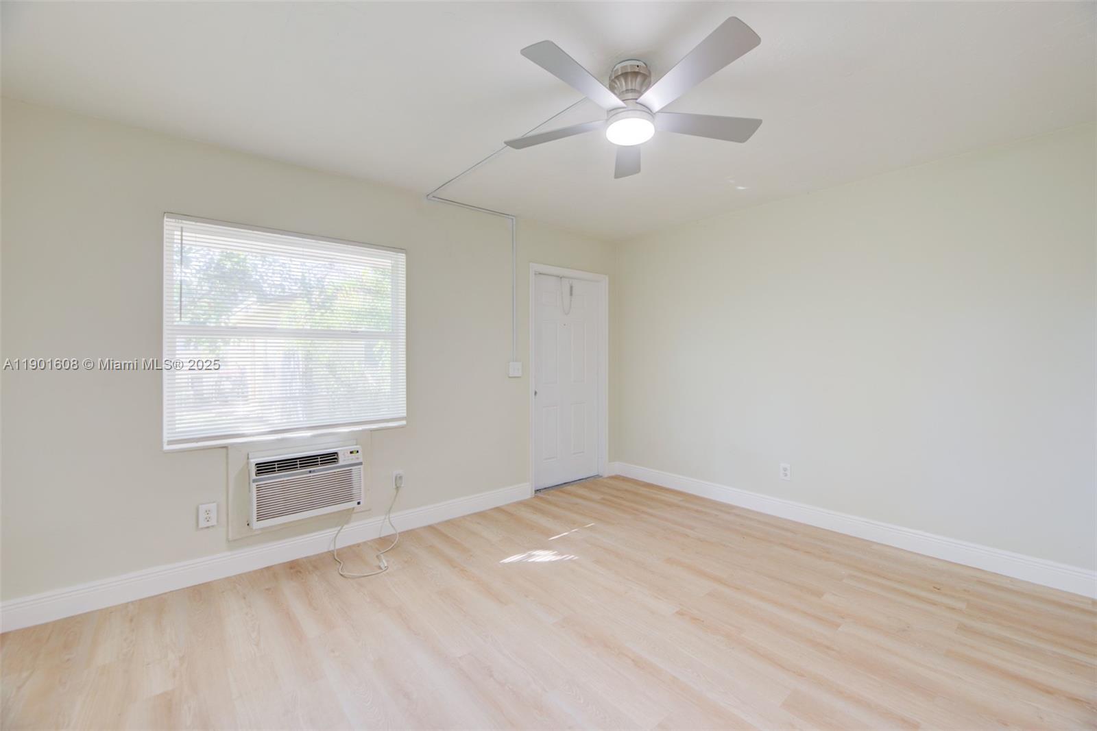 1880 Northwest 59th Way Sunrise, FL 33313 - Photo 8 of 27 wooden floor in an empty room with a window