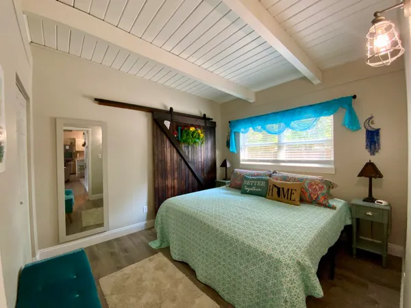 a bedroom with a bed and a dresser next to a window