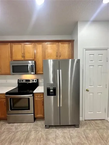 a kitchen with stainless steel appliances granite countertop a refrigerator a stove a sink and cabinets