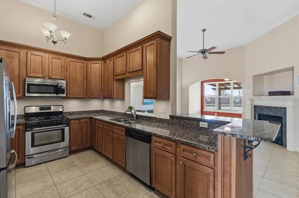 a kitchen with stainless steel appliances granite countertop a stove top oven a sink and dishwasher