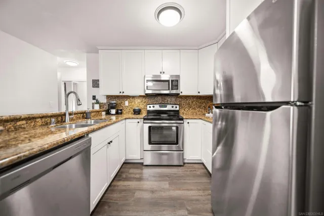 a kitchen with granite countertop a refrigerator and a sink