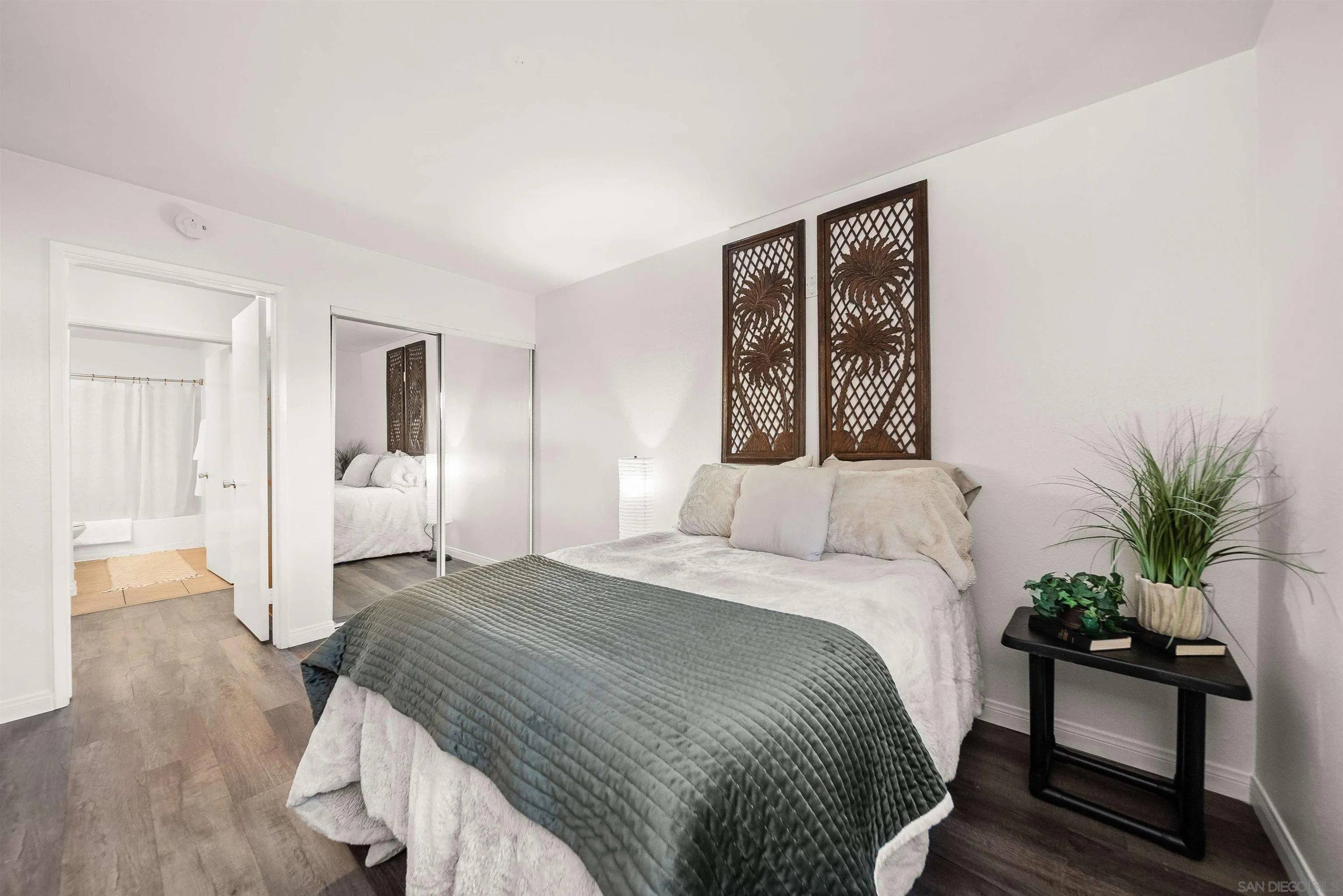 6191 Rancho Mission Road, Unit 103 San Diego, CA 92108 - Photo 9 of 28 a bedroom with a bed and a potted plant