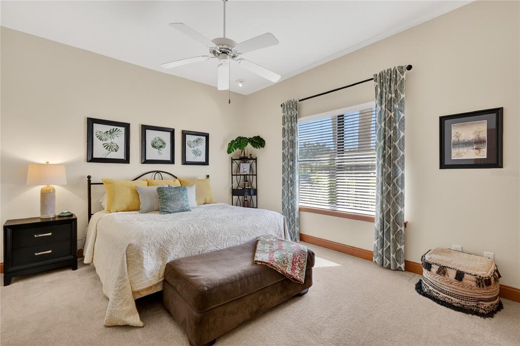 16238 East Shirley Shores Road Tavares, FL 32778 - Photo 28 of 48 a bedroom with a bed and a chandelier