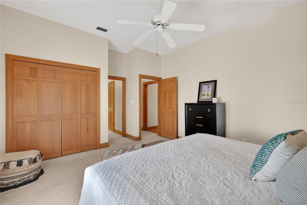 16238 East Shirley Shores Road Tavares, FL 32778 - Photo 29 of 48 a bedroom with a bed and a chandelier