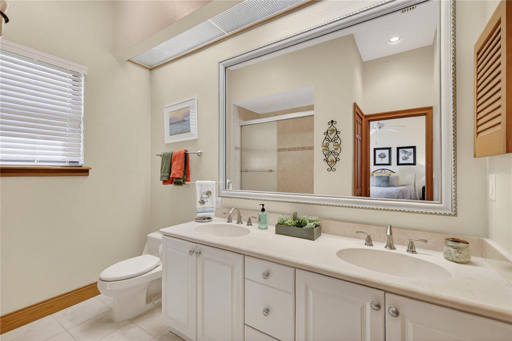 16238 East Shirley Shores Road Tavares, FL 32778 - Photo 30 of 48 a bathroom with a granite countertop toilet sink and a mirror
