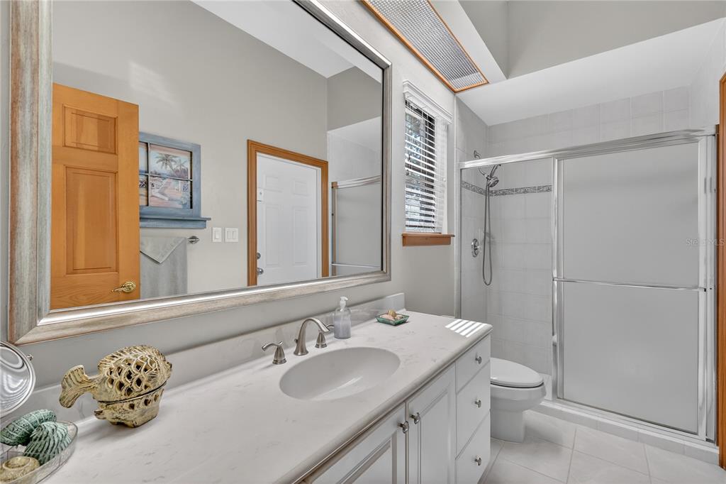 16238 East Shirley Shores Road Tavares, FL 32778 - Photo 33 of 48 a bathroom with a granite countertop sink toilet and shower