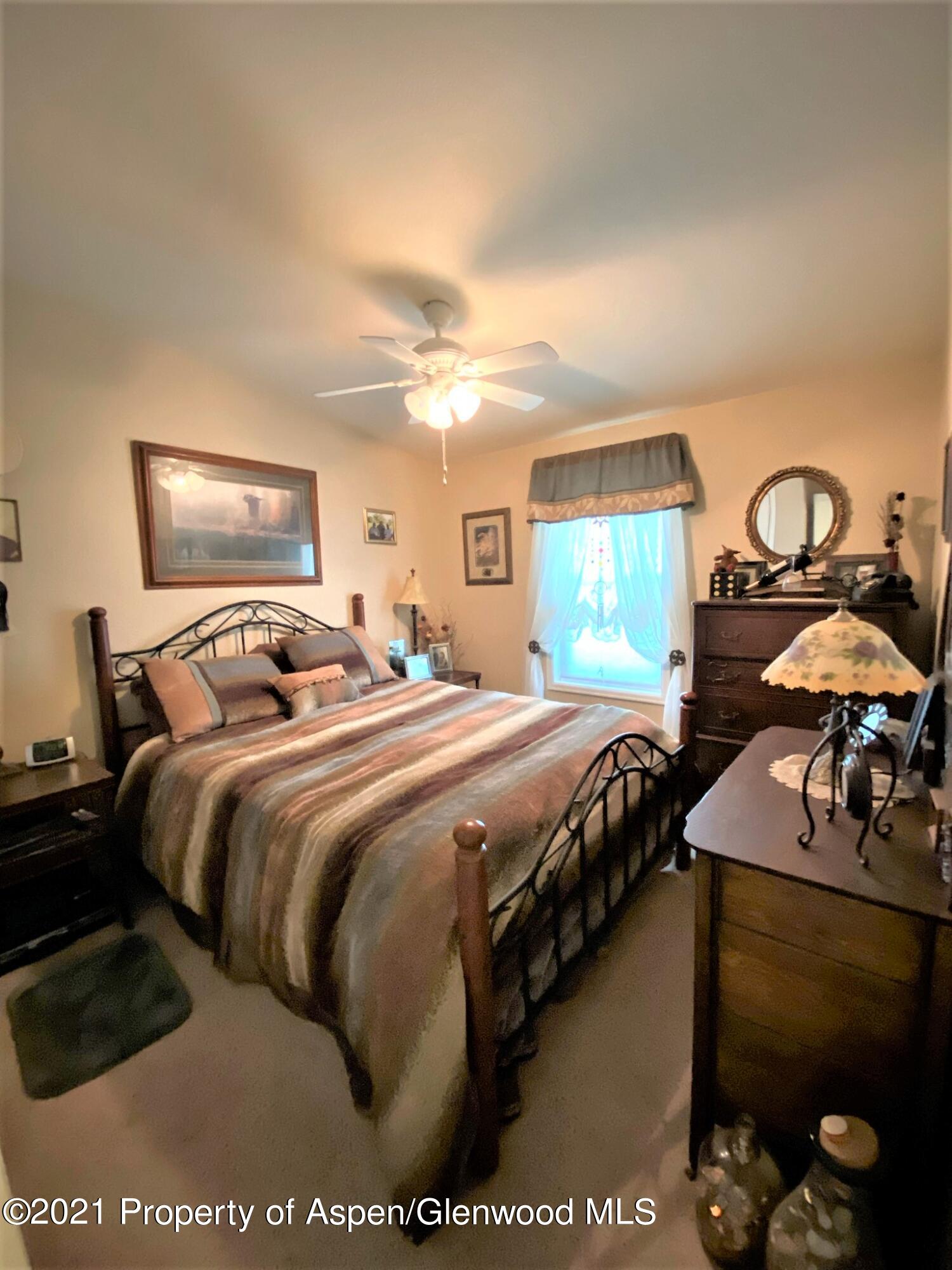 429 East 4th Street Rifle, CO 81650 - Photo 17 of 29 a bedroom with a bed and a lamp on dresser
