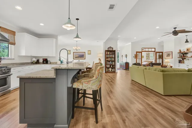 a kitchen with stainless steel appliances granite countertop a sink a window and cabinets