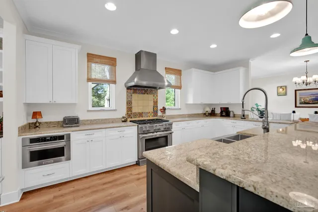 a large kitchen with kitchen island a stove a sink a refrigerator and a granite counter tops