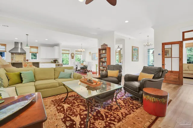 a kitchen with stainless steel appliances granite countertop a stove top oven a sink dishwasher and a dining table with wooden floor