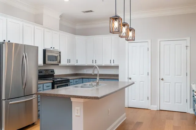 a kitchen with granite countertop a refrigerator and a sink