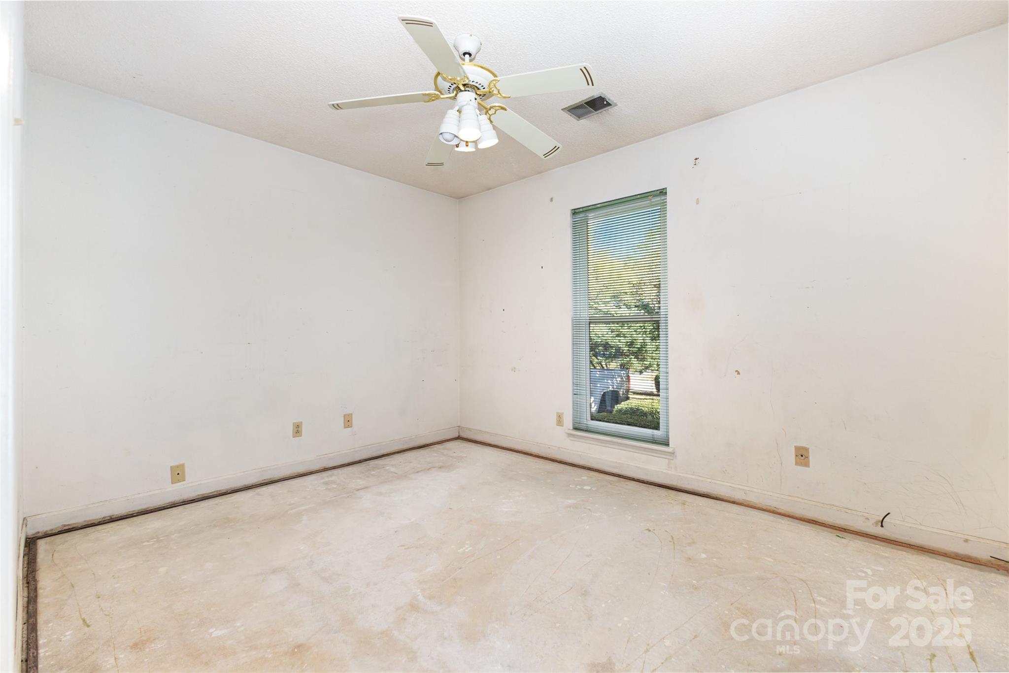 7428 Bradgate Road Charlotte, NC 28217 - Photo 17 of 27 an empty room with a chandelier fan and windows