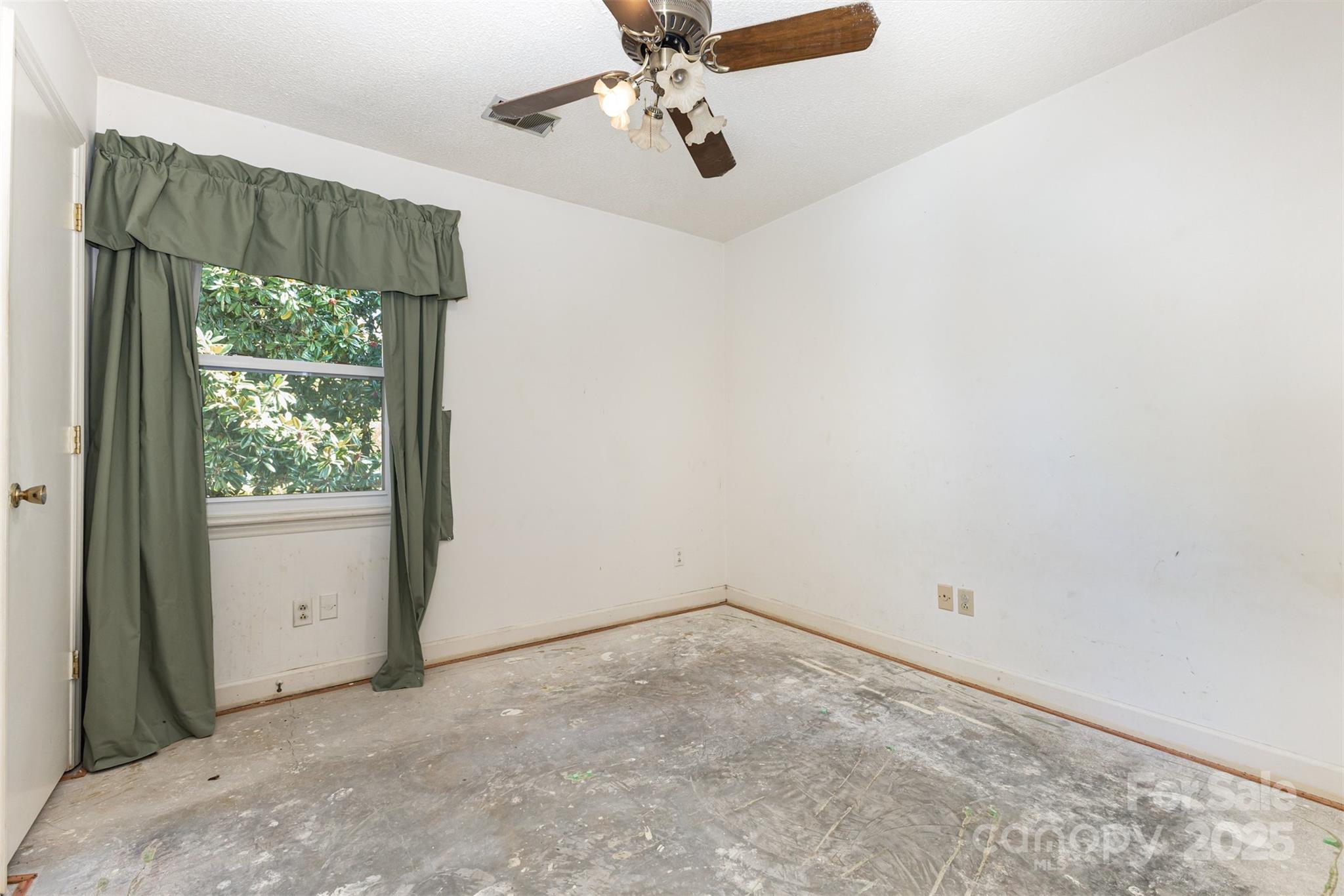 7428 Bradgate Road Charlotte, NC 28217 - Photo 19 of 27 an empty room with a window and a fan