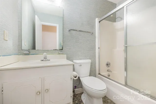 a bathroom with a granite countertop toilet sink and a mirror