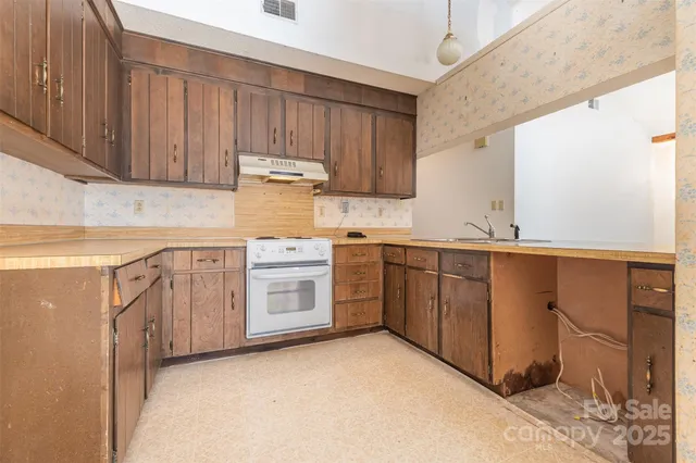 a kitchen with sink a stove and cabinets