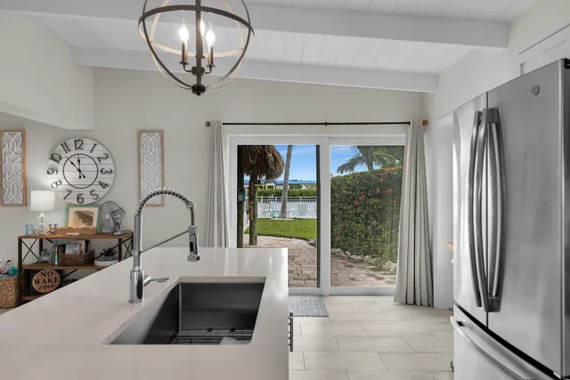 a living room with stainless steel appliances furniture a fireplace and a view of kitchen