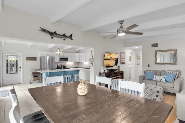 a living room with furniture wooden floor and a kitchen view