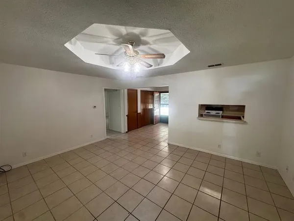 an empty room with windows and ceiling fan
