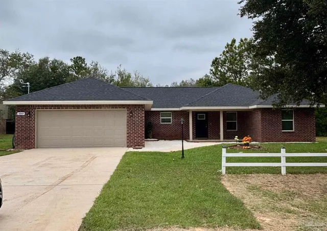 a front view of a house with a yard and trees