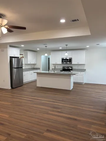 a large kitchen with stainless steel appliances granite countertop a stove a sink dishwasher and a refrigerator