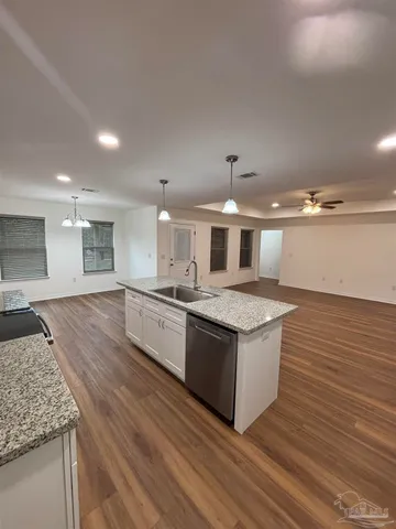 a kitchen with stainless steel appliances granite countertop a stove and a wooden floors