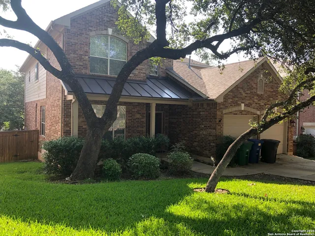 a view of a house with backyard and a tree