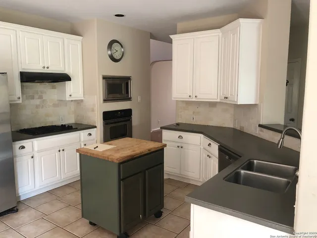 a kitchen with stainless steel appliances granite countertop a sink stove and cabinets