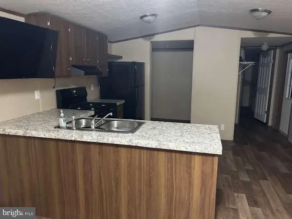 a kitchen with granite countertop a sink a stove and a refrigerator