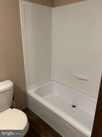 a bathroom with a toilet and bathtub