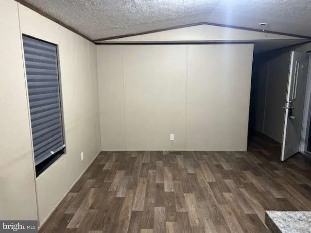 a view of a room with wooden floor and a hallway