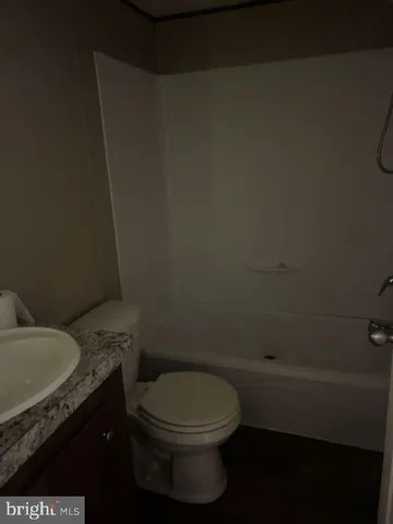 a bathroom with a granite countertop toilet and a sink