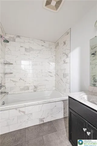a bathroom with a granite countertop sink a toilet and shower