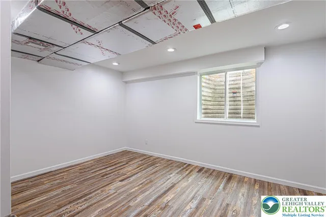 a view of a white house with a yard and lawn chairs under an umbrella