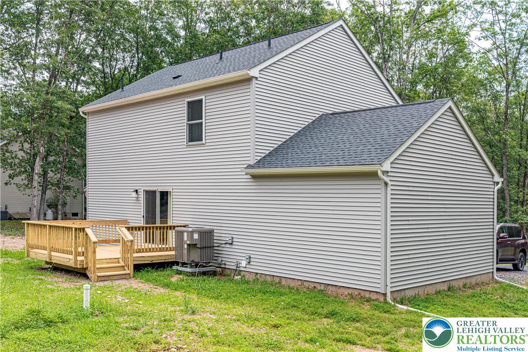 117 Cress Drive Effort, PA 18330 - Photo 24 of 29 a view of a white house with a yard and lawn chairs under an umbrella