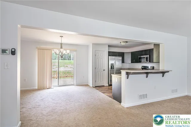 a view of a kitchen with stainless steel appliances kitchen island granite countertop a refrigerator stove oven with a sink and dishwasher