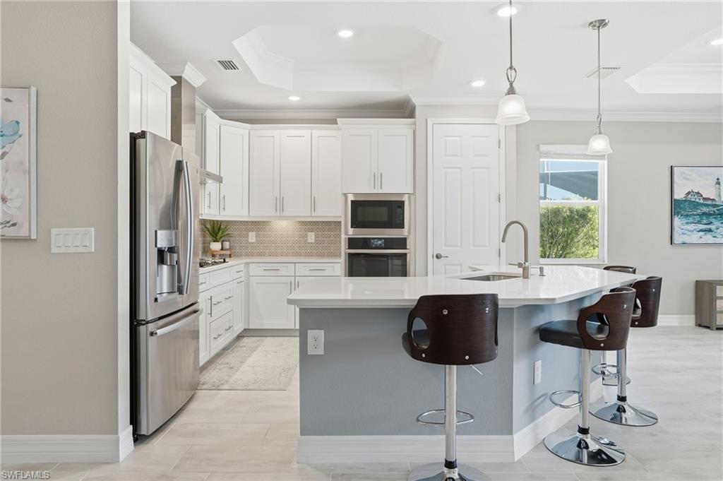 15194 Blue Bay Circle Fort Myers, FL 33913 - Photo 16 of 50 a kitchen with stainless steel appliances granite countertop a stove refrigerator and cabinets