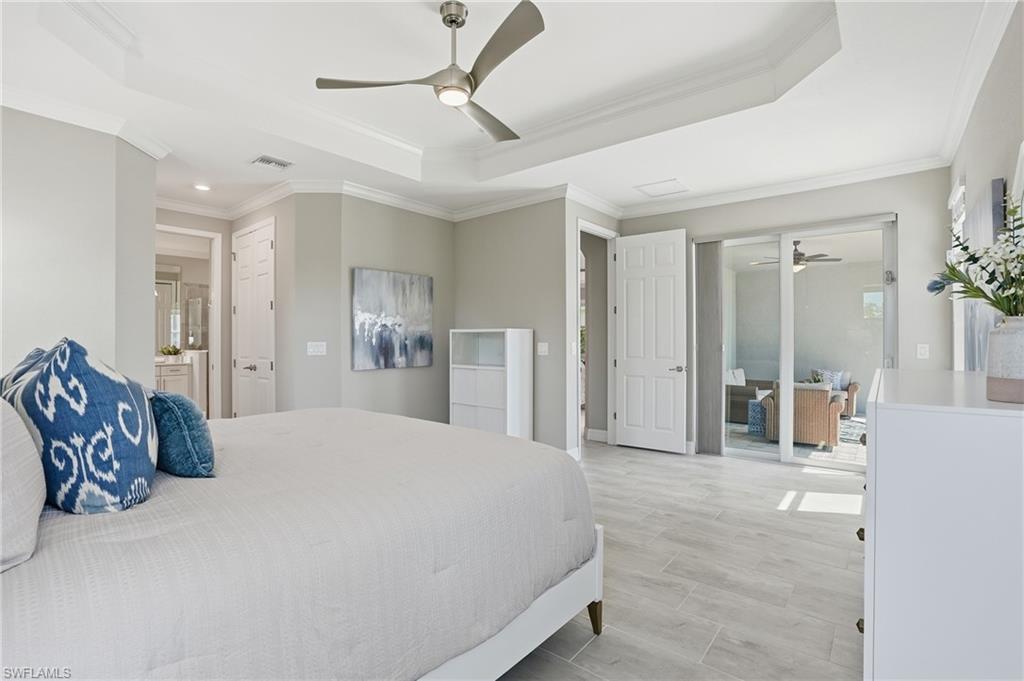 15194 Blue Bay Circle Fort Myers, FL 33913 - Photo 23 of 50 a bedroom with a large bed and a chandelier