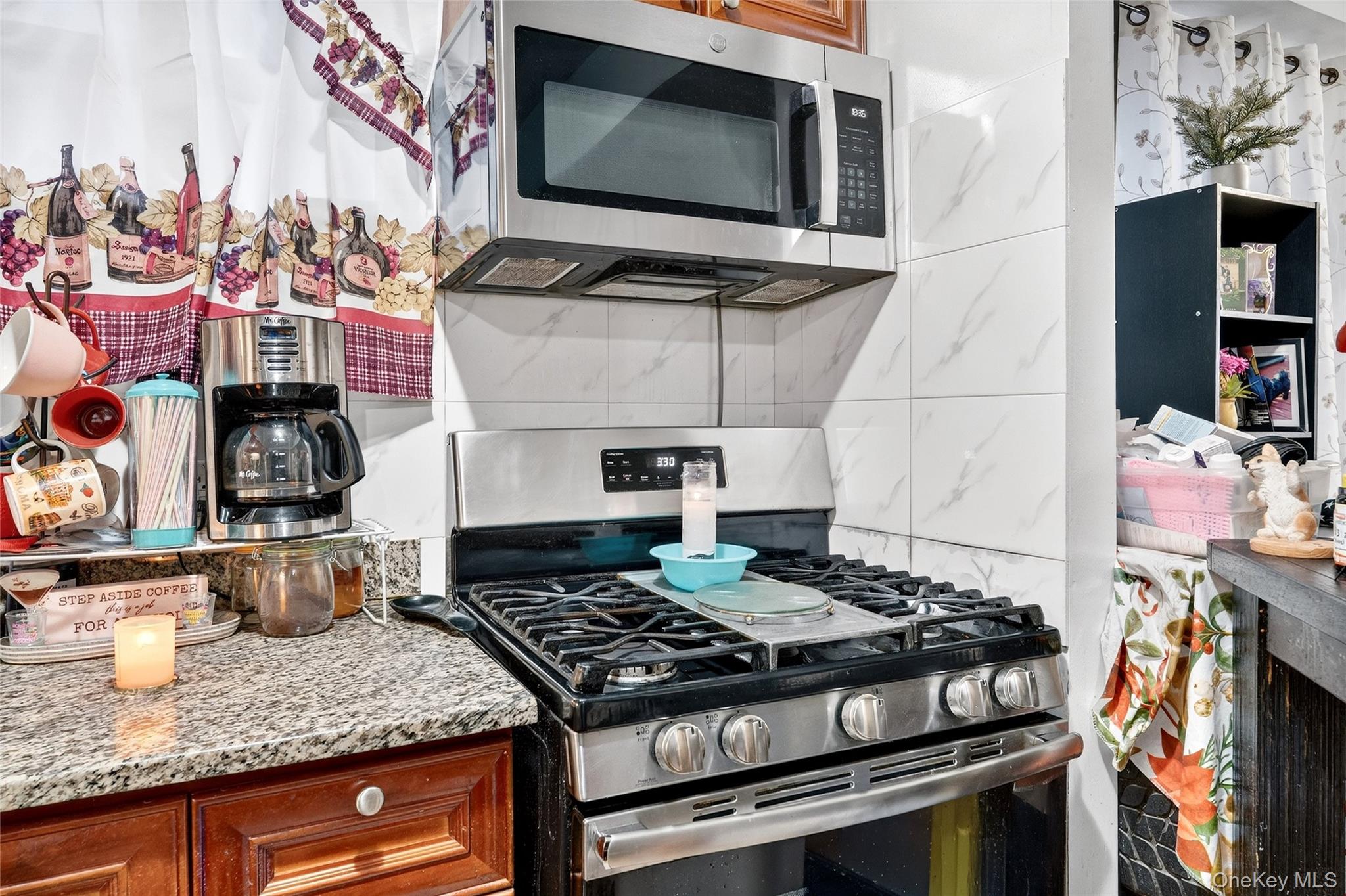 1459 Rosedale Avenue Bronx, NY 10460 - Photo 9 of 37 Kitchen featuring appliances with stainless steel finishes, brown cabinets, and light stone countertops