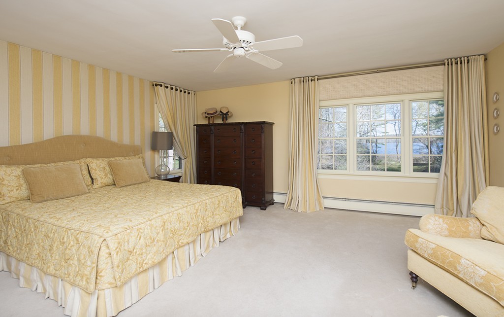 61 Sandy Pond Road Lincoln, MA 01773 - Photo 14 of 28 a spacious bedroom with a large bed and a chandelier