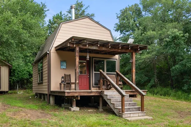 a view of house with a yard and deck