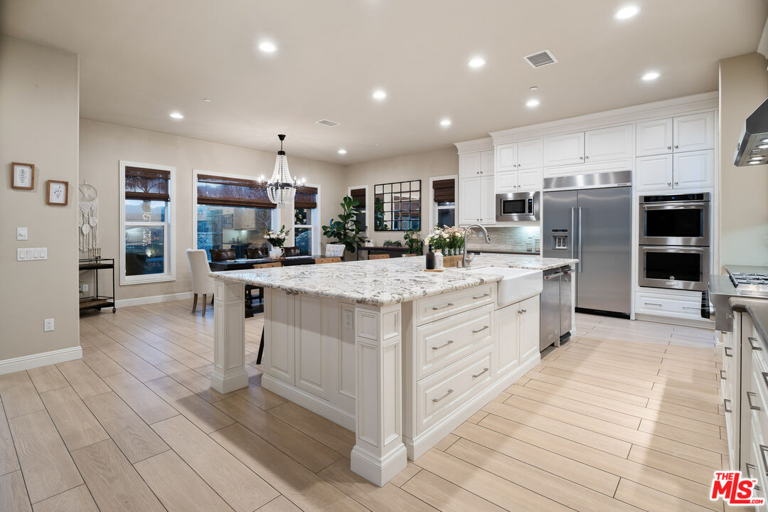 12015 North Ricasoli Way Porter Ranch, CA 91326 - Photo 13 of 68 a kitchen with stainless steel appliances kitchen island granite countertop a stove and a refrigerator