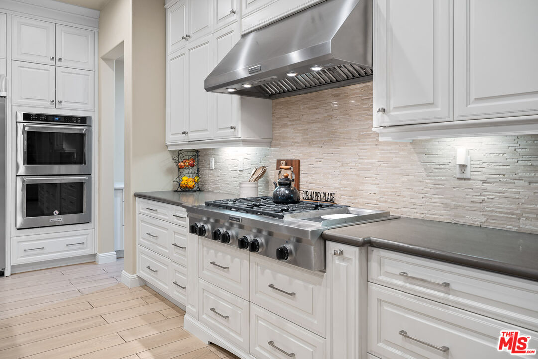 12015 North Ricasoli Way Porter Ranch, CA 91326 - Photo 14 of 68 a kitchen with white cabinets and appliances