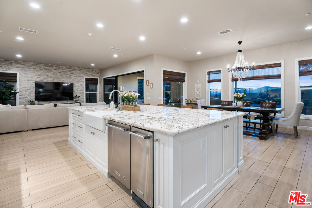 12015 North Ricasoli Way Porter Ranch, CA 91326 - Photo 17 of 68 a kitchen with stainless steel appliances kitchen island granite countertop a stove and a sink