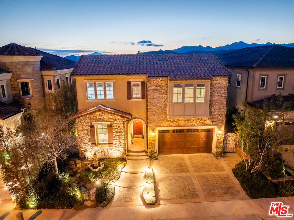 12015 North Ricasoli Way Porter Ranch, CA 91326 - Photo 3 of 68 a view of a brick house with many windows