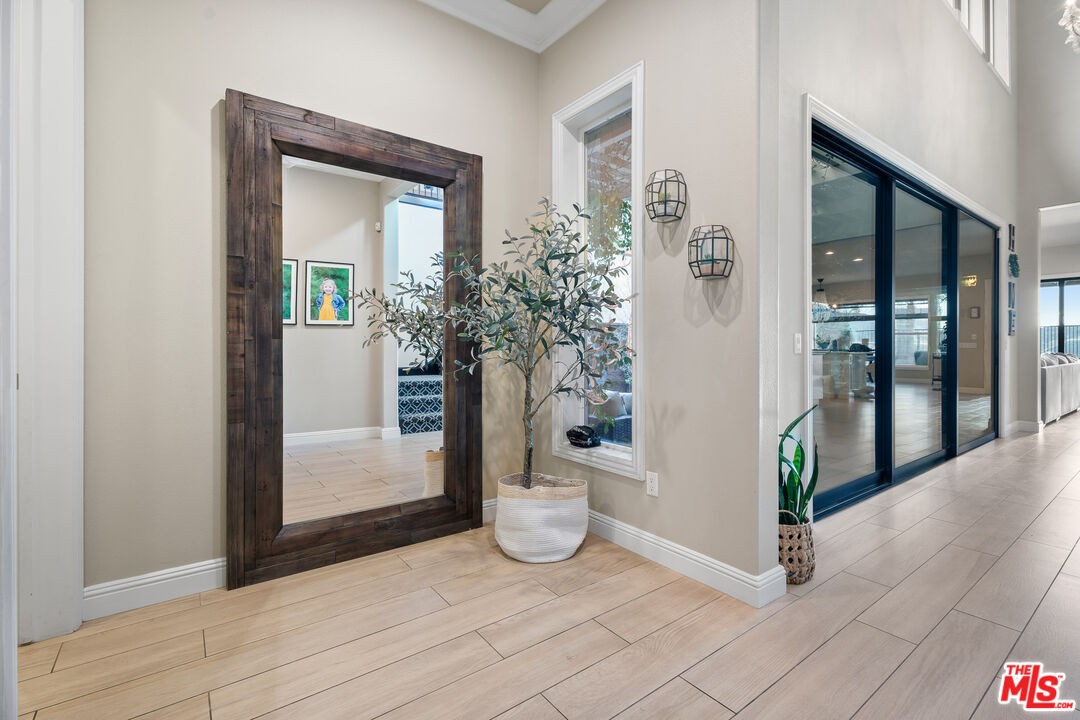 12015 North Ricasoli Way Porter Ranch, CA 91326 - Photo 10 of 68 a view of a hallway with wooden floor and a potted plant
