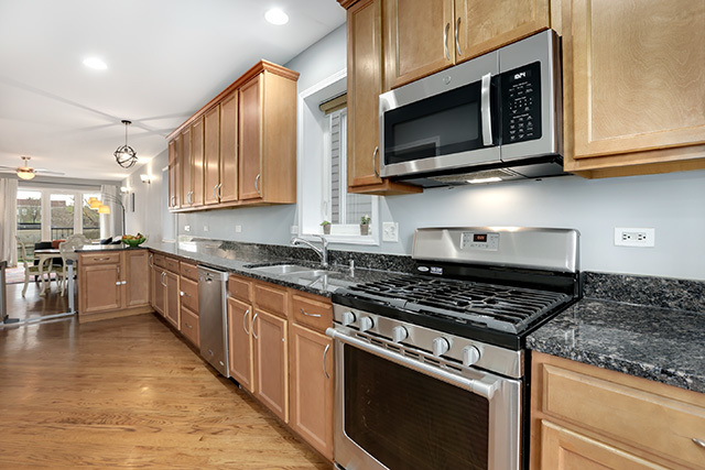 1731 South Ruble Street, Unit 1 Chicago, IL 60616 - Photo 11 of 25 a kitchen with stainless steel appliances granite countertop a stove top oven microwave and cabinets