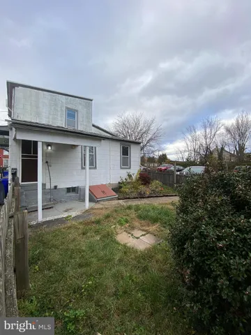 a front view of house with yard and trees in the background