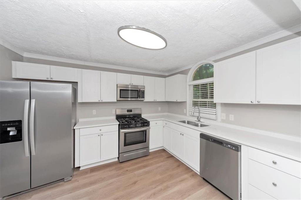710 Country Manor Way Alpharetta, GA 30022 - Photo 15 of 33 a kitchen with stainless steel appliances granite countertop a sink stove and refrigerator