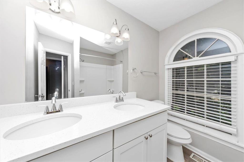 710 Country Manor Way Alpharetta, GA 30022 - Photo 16 of 33 a bathroom with a sink a toilet and a large mirror