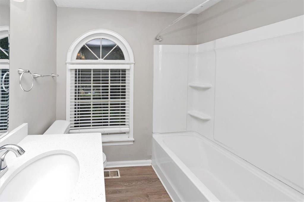 710 Country Manor Way Alpharetta, GA 30022 - Photo 17 of 33 a bathroom with a window a bathtub and a shower